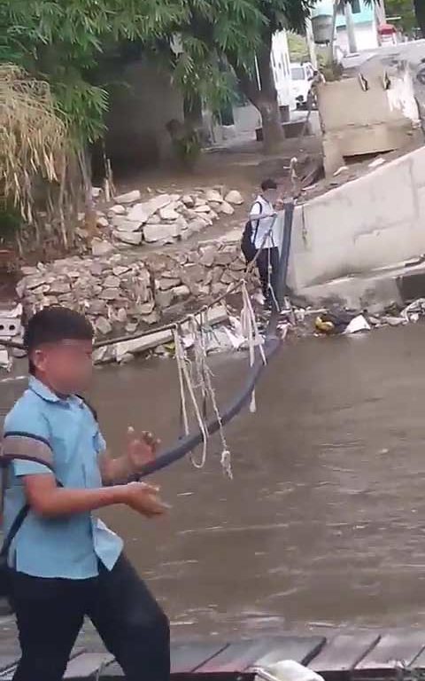 Bimbi in bilico su una fune per superare fiume pieno di coccodrilli e andare a scuola